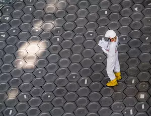 Travailleur combinaison blanche jaune structure hexagonale industrielle vue aérienne