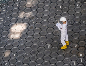 Travailleur combinaison blanche jaune structure hexagonale industrielle vue aérienne