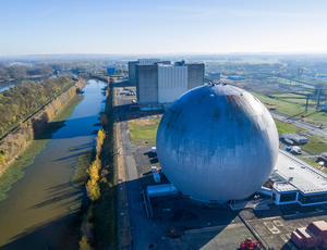 Vue aérienne d'une usine industrielle sphérique bleue au bord de l'eau