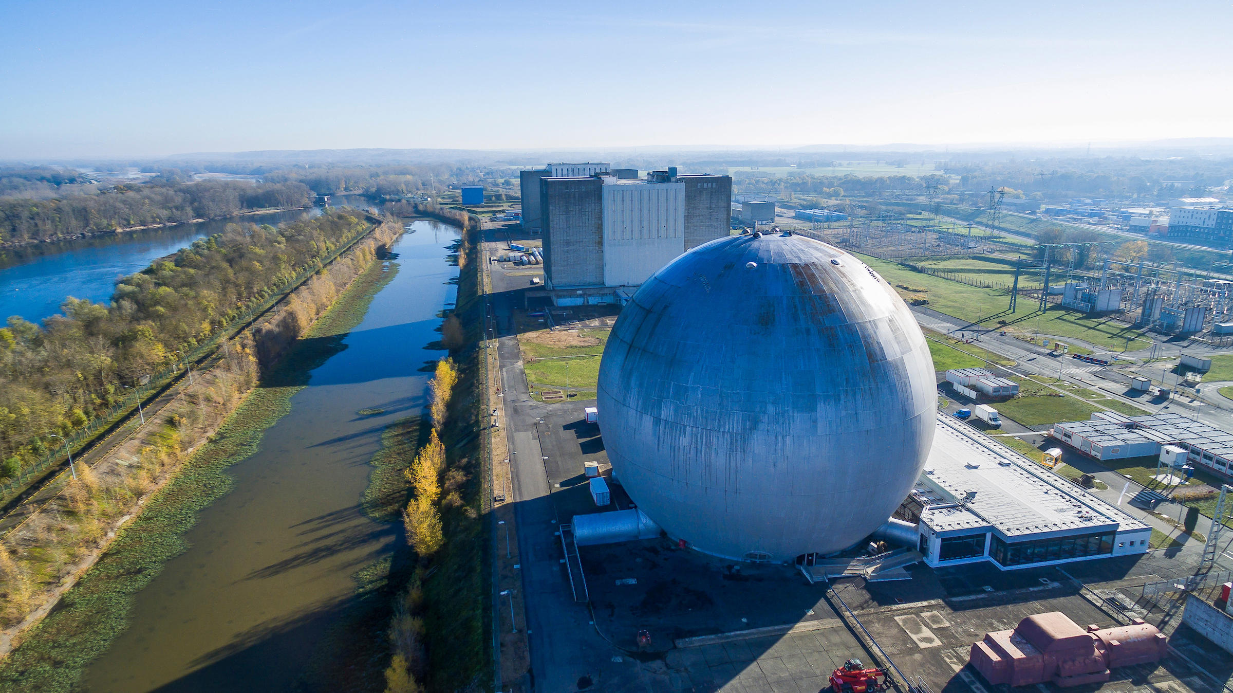 Vue aérienne d'une usine industrielle sphérique bleue au bord de l'eau